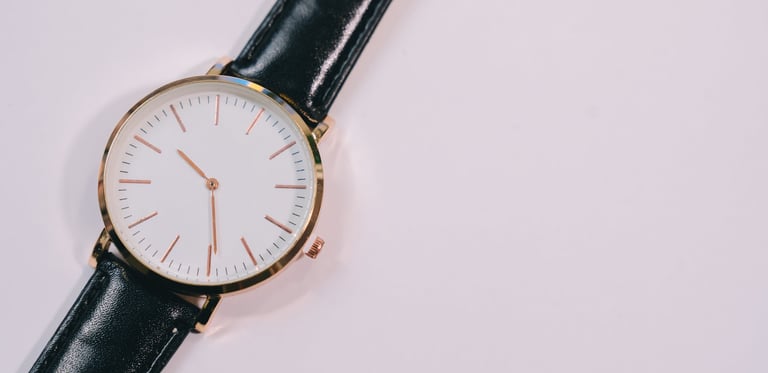Minimalist wristwatch with black leather strap and white dial, elegant design