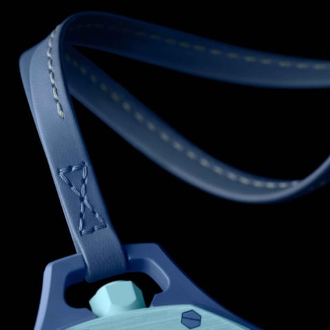 Blue lanyard with stitched detail attached to light blue badge holder with hexagonal clip against black background